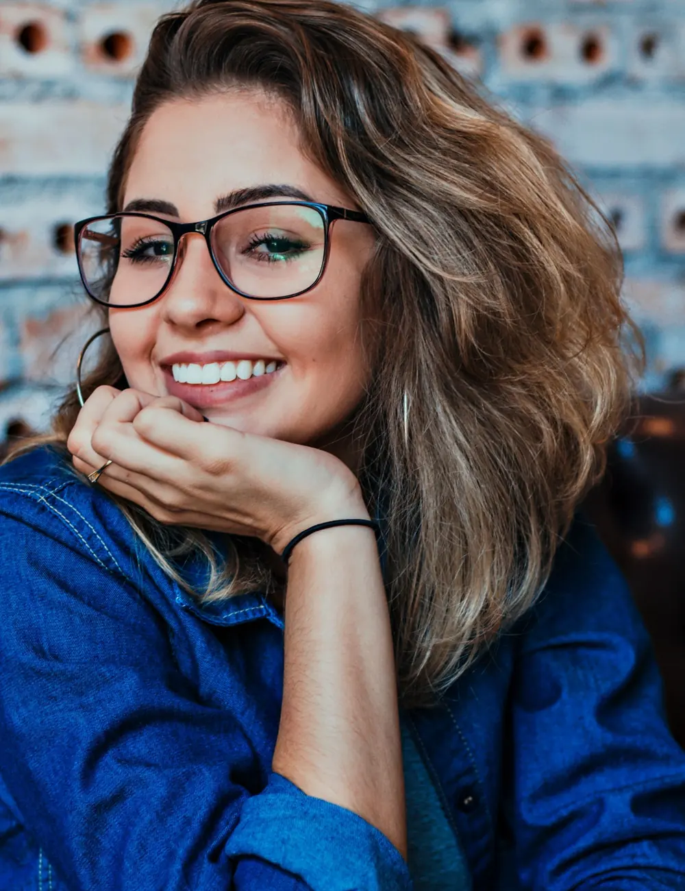 Smiling woman wearing glasses and a denim shirt